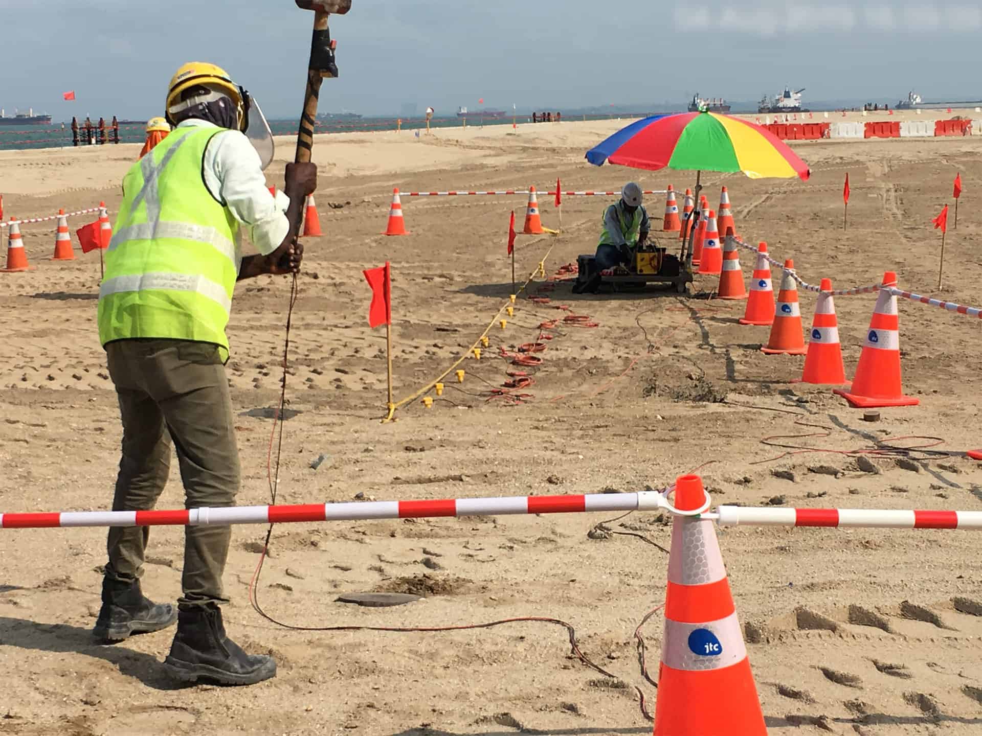 Engineer lifting sledge hammer during MASW (Multichannel Analysis of Surface Waves) survey